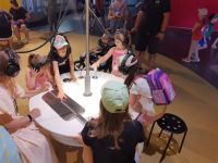 Dzieci eksperymentujące z urządzeniami na stole w słuchawkach na uszach